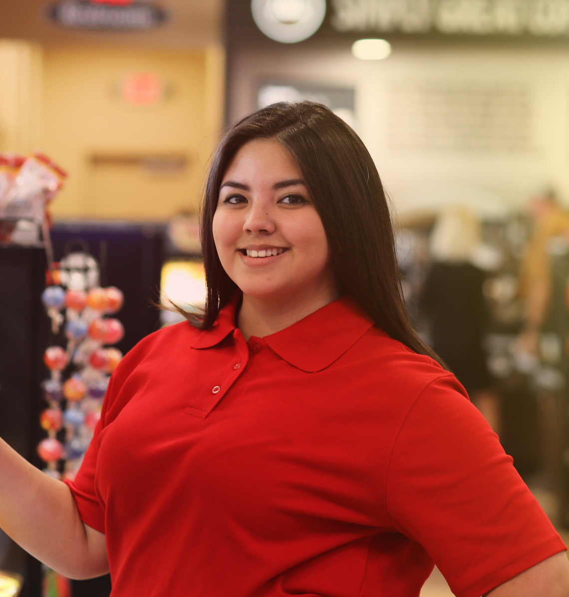 A convenience store employee smiling behind the counter